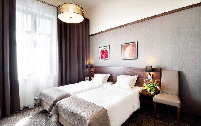 Twin beds met schilderijen van hotel Golden Tulip Krakow City Center stedentrip Krakau